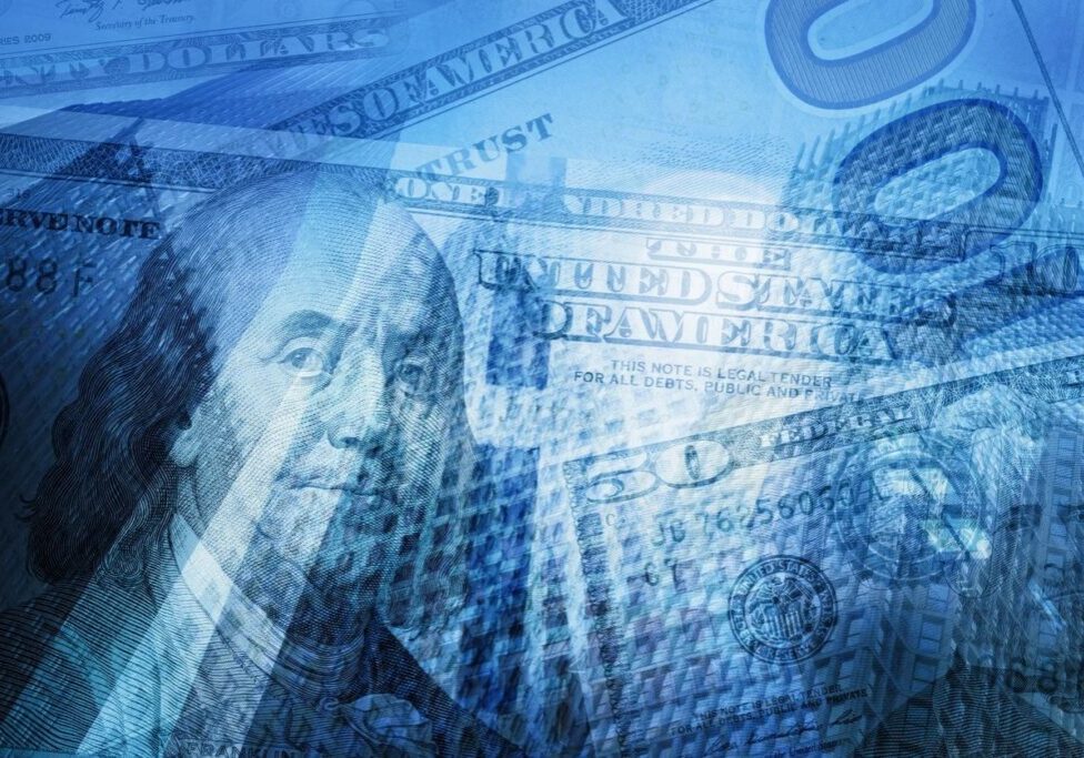 Close-up of overlapping US dollar bills, highlighting Benjamin Franklin's portrait.