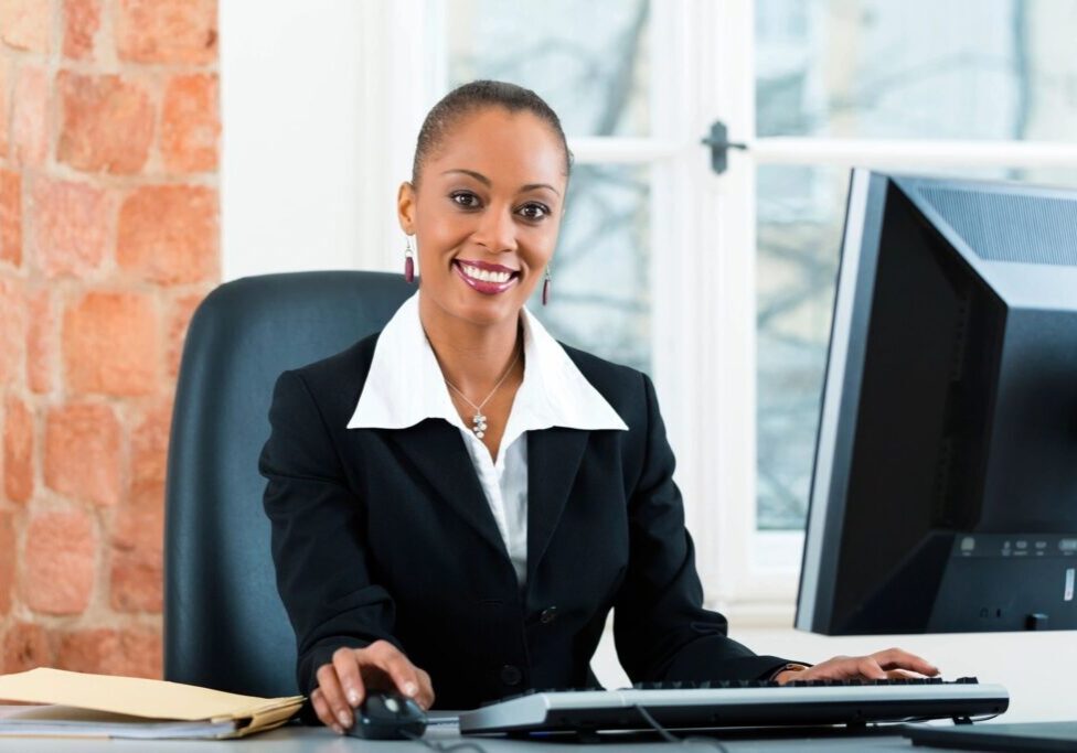 Professional woman smiling while working at her desk.