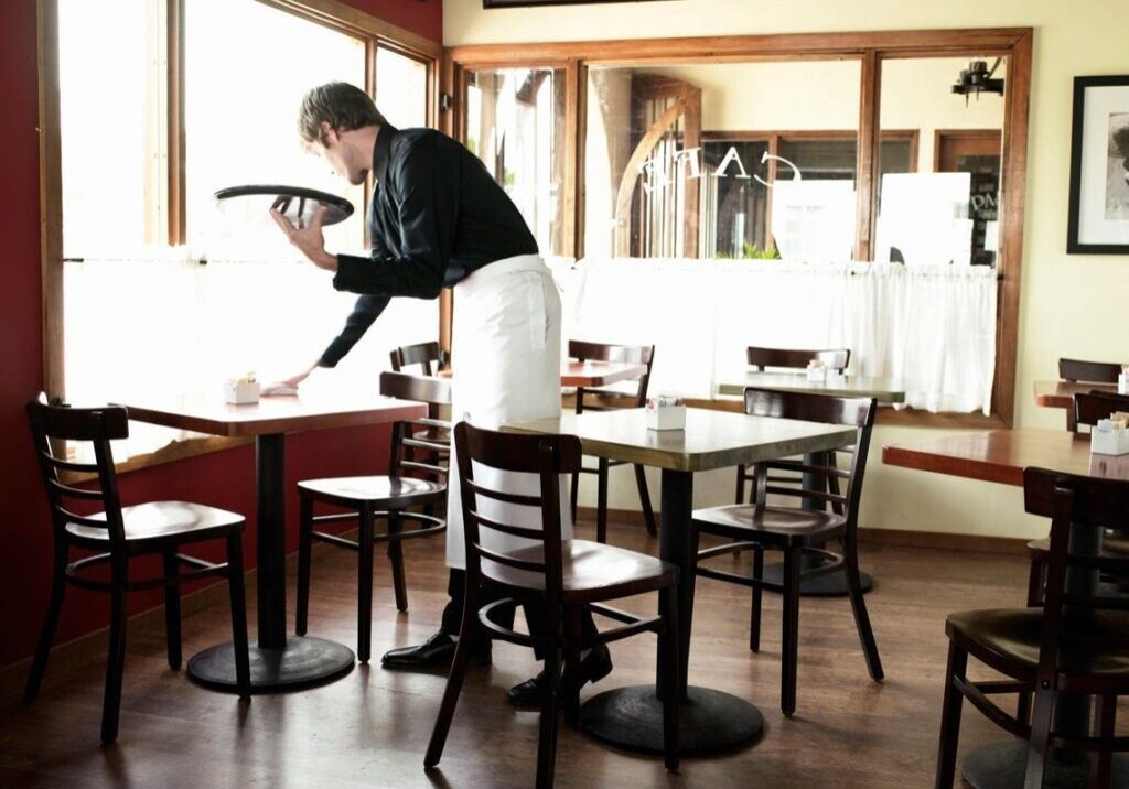 Waitress cleaning a restaurant table.